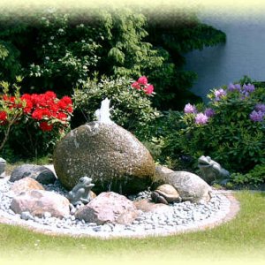 Granit-Findling als Quellstein mit Pfeffer&amp;Salz-Kiesbett