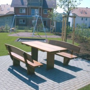 Sitzgruppe aus Holz-Bänken und -Tisch,  Pflasterfläche Rechteckpflaster       grau